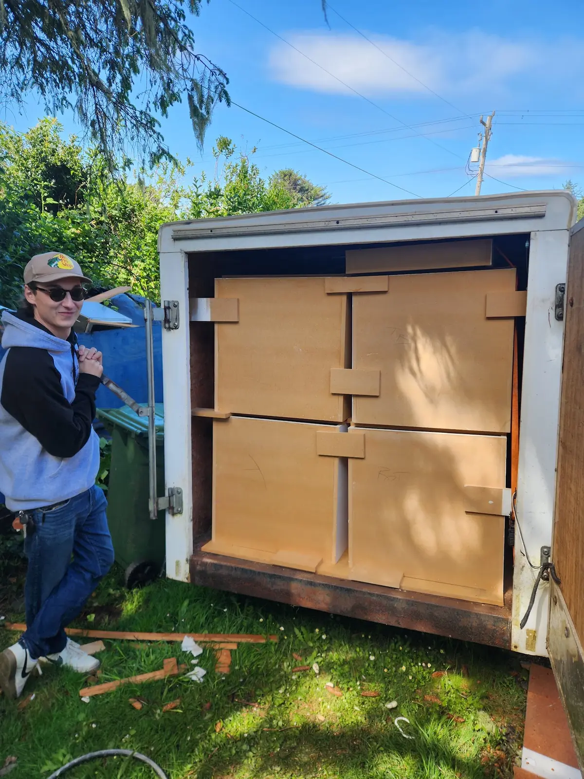Justin with protected cabinet components loaded into a project trailer